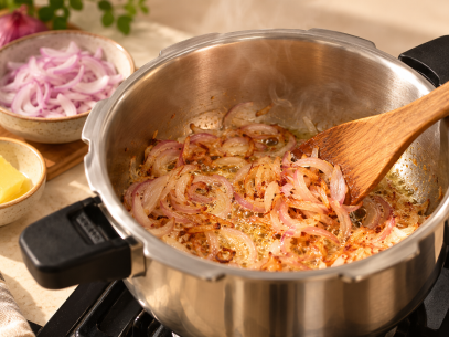SAUTÉ Heat 2 tbsp ghee in a pressure cooker. Sauté onions until golden.